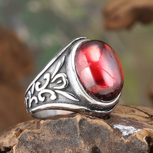 Retro stainless steel flower ring featuring a large oval red zircon and floral relief