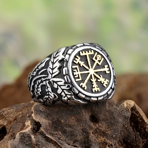 Vintage Viking compass signet ring for men in silver and gold tone on a wooden base