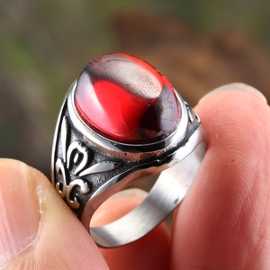 Vintage stainless steel ring featuring a large oval red zircon and floral engravings