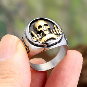 Detail of vintage gothic skull signet ring featuring golden skull and bone hands