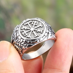 Vintage steel viking vegvisir compass ring with braided texture held by fingers