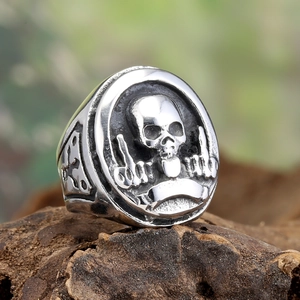 Vintage punk skull ring in stainless steel featuring cross patterns on dark wood bark