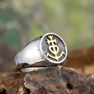 Vintage anchor cross steel signet ring for men on a natural wood block background