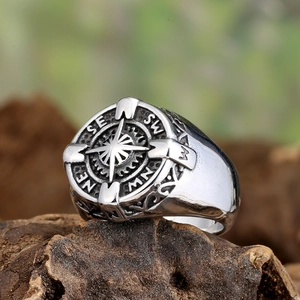 Vintage silver stainless steel compass ring with zircon star on natural wood background