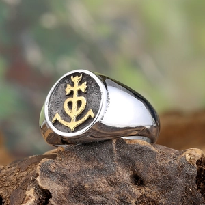 Men's vintage steel signet ring with golden Camargue cross on rustic wood base