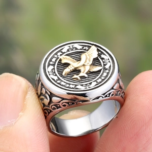 Vintage stainless steel men's signet ring featuring a golden eagle relief and scrollwork