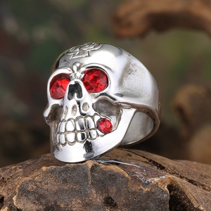 Macro shot of vintage skull ring with red gemstone eyes and cross engraving on titanium steel