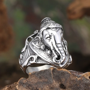 Macro shot of retro Ganesha elephant ring with embossed details on wood background