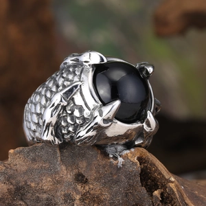 Macro view of punk dragon claw ring with black gemstone and detailed scale texture