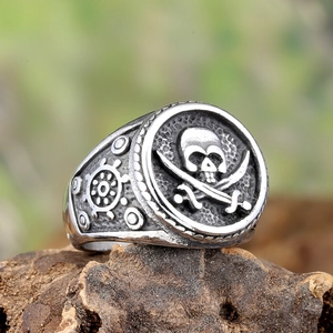 Detailed macro shot of vintage pirate skull and steering wheel relief on stainless steel ring