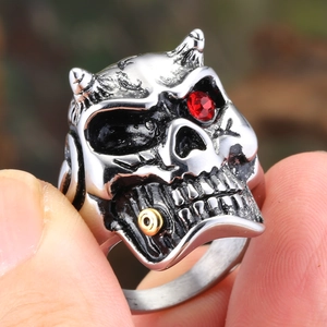 Retro punk skull ring in stainless steel with a red gemstone eye and gold ring detail