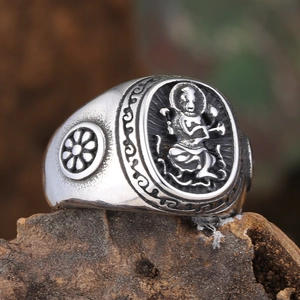 Vintage Tibetan Buddhist ring with deity relief and floral carvings on wooden base