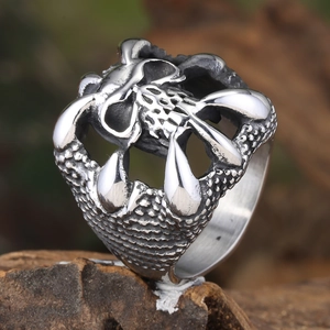 Vintage gothic punk skull ring for men in polished titanium steel on wood background