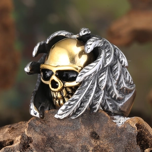 Gothic punk skull wings ring in polished gold and silver stainless steel on wood
