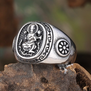 Macro shot of Tibetan vintage ring with deity carving on textured wood bark