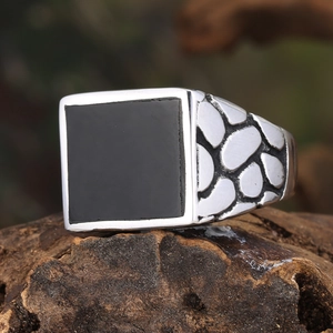 Macro detail of men's vintage signet ring with black onyx inlay and textured band side