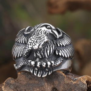Gothic raven hawk stainless steel ring with vintage finish on a rustic wood background