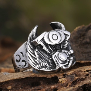 Macro shot of punk engine ring with wing details on rustic wood background