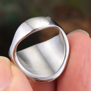 Close-up of a wide polished titanium steel ring with brushed metal texture for men