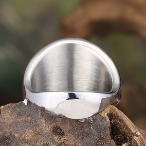Polished silver titanium steel ring for men with a wide brushed finish on a wood base