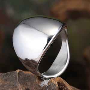 Polished silver titanium steel ring with wide arc mirror top on rustic wood base