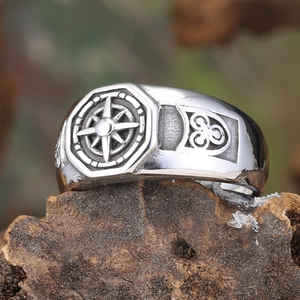 Macro d'une bague étoile boussole en argent avec nœuds celtiques sur surface en bois