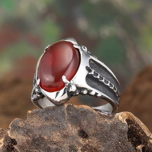 Close-up of vintage punk ring with red oval agate stone and claw-carved silver band