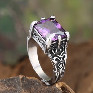 Detailed side view of vintage punk ring with rectangle purple gemstone and vine carvings