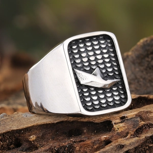 Macro shot of men's titanium steel signet ring with origami boat and fish scale pattern