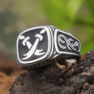 Macro detail of retro men's steel ring with black enamel and crossed swords on wood