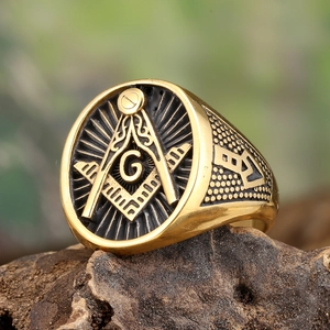 Détail macro d'une bague franc-maçon vintage dorée avec l'œil de la Providence sur bois