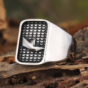 Polished silver titanium steel signet ring with origami paper boat design on rustic wood