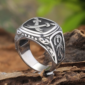 Retro stainless steel men's ring with crossed sabers emblem on rustic wood background