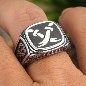 Macro shot of men's vintage silver ring with black rectangle and crossed scimitars