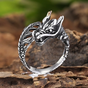 Macro shot of vintage silver dragon ring with intricate scales on a wooden base