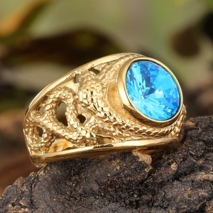 Macro shot of gold punk ring with blue gemstone and unique textured scale engraving