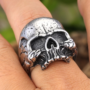 Retro punk style skull ring in silver metal with distressed texture worn on finger