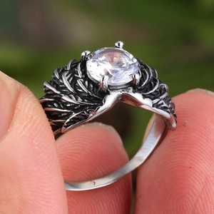 Macro shot of retro silver ring with feather wings texture and large round gemstone