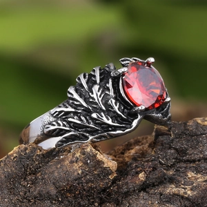 Retro mens wing ring with large round red gemstone on natural wooden bark background