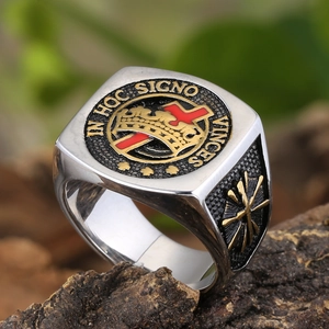 Détail de bague chevalière vintage avec croix rouge, couronne dorée et gravure latine