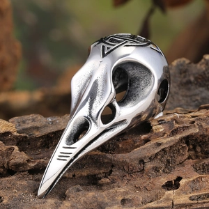 Macro shot of Viking stainless steel raven skull pendant with Nordic knotwork engraving