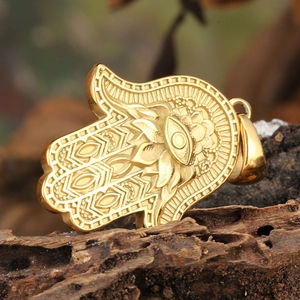 Golden Hamsa Hand pendant with All-seeing Eye on a rustic textured wood background