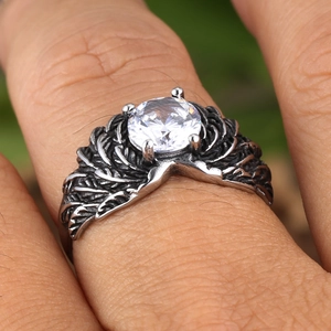 Detail view of vintage wing ring featuring feather textures and a clear round zircon stone