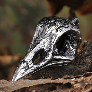 Macro shot of gothic crow skull pendant with vintage bone texture on rustic wood
