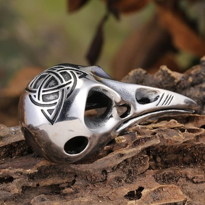 Vintage stainless steel viking crow skull ring with celtic knot engraving on aged wood