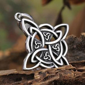 Vintage Celtic shield knot pendant in stainless steel on textured wood background