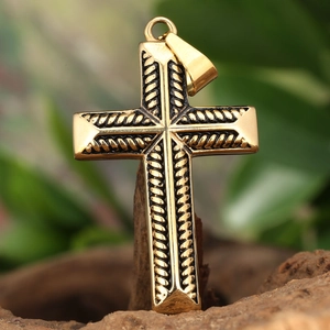 Macro view of golden stainless steel cross pendant with black vintage rope texture detail