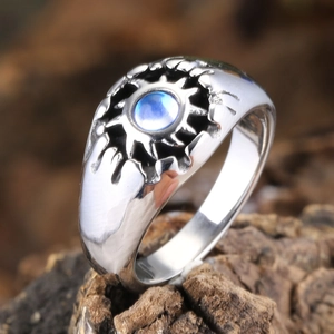 Vintage unisex ring with moonstone sunburst design on dark wood background