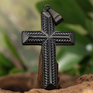 Black stainless steel cross pendant with rope pattern on a natural wooden base