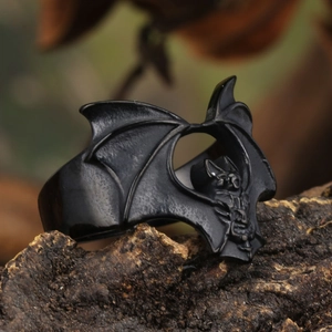 Gothic men's black bat ring in vintage stainless steel on a textured rock background